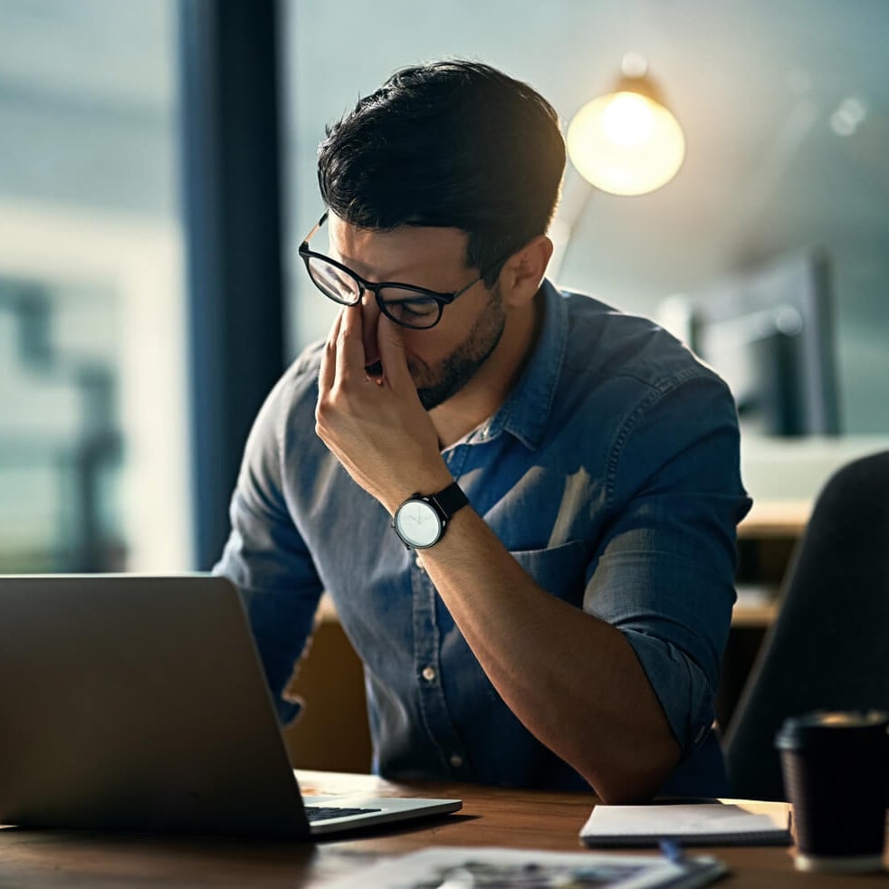 Man thinking in front of laptop